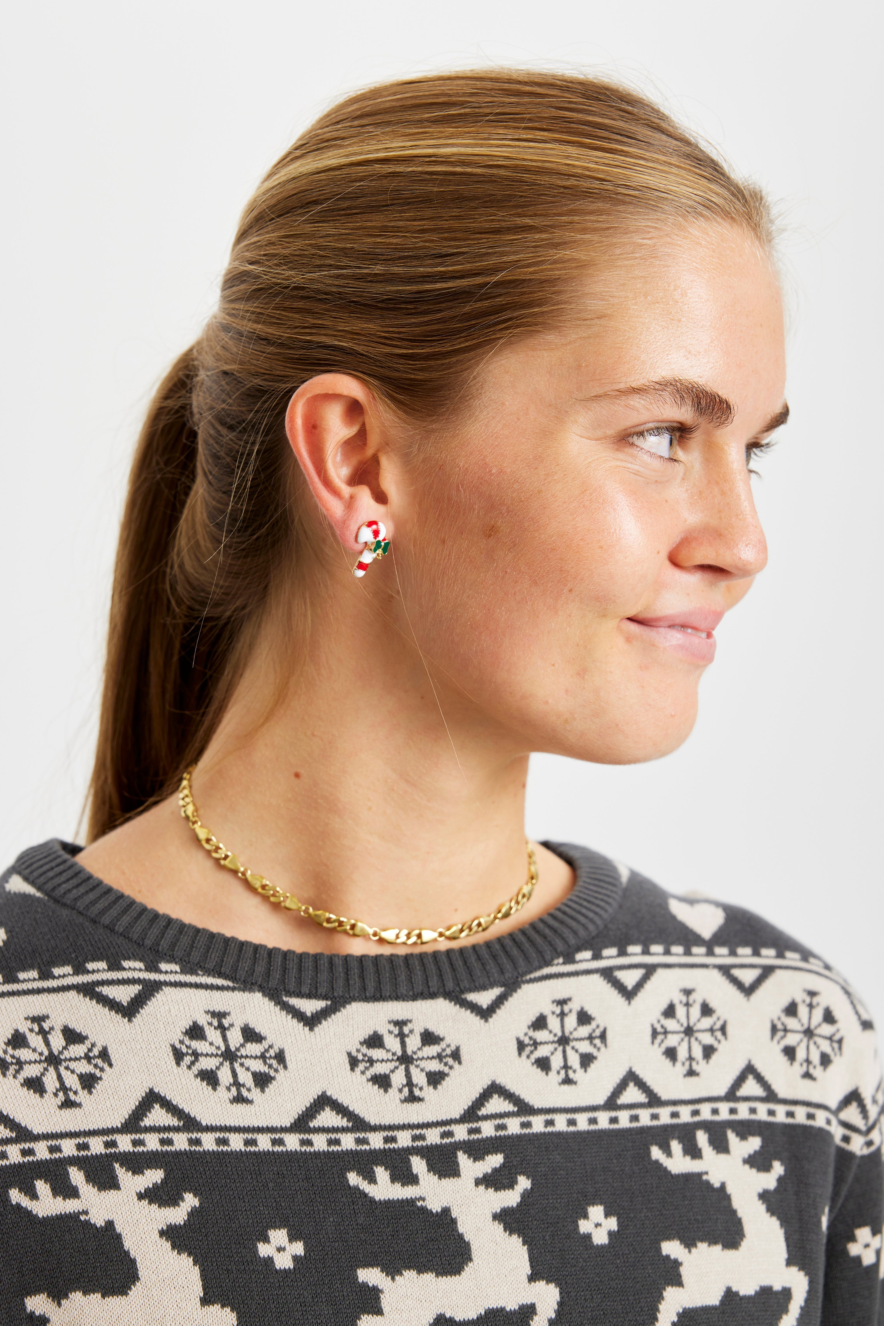 Eine Frau trägt Weihnachtsohrringe.